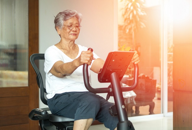 En gammal kvinna på en motionscykel
